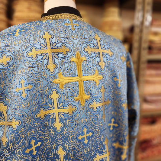 Blue fabric with gold cross patterns on a blurred background