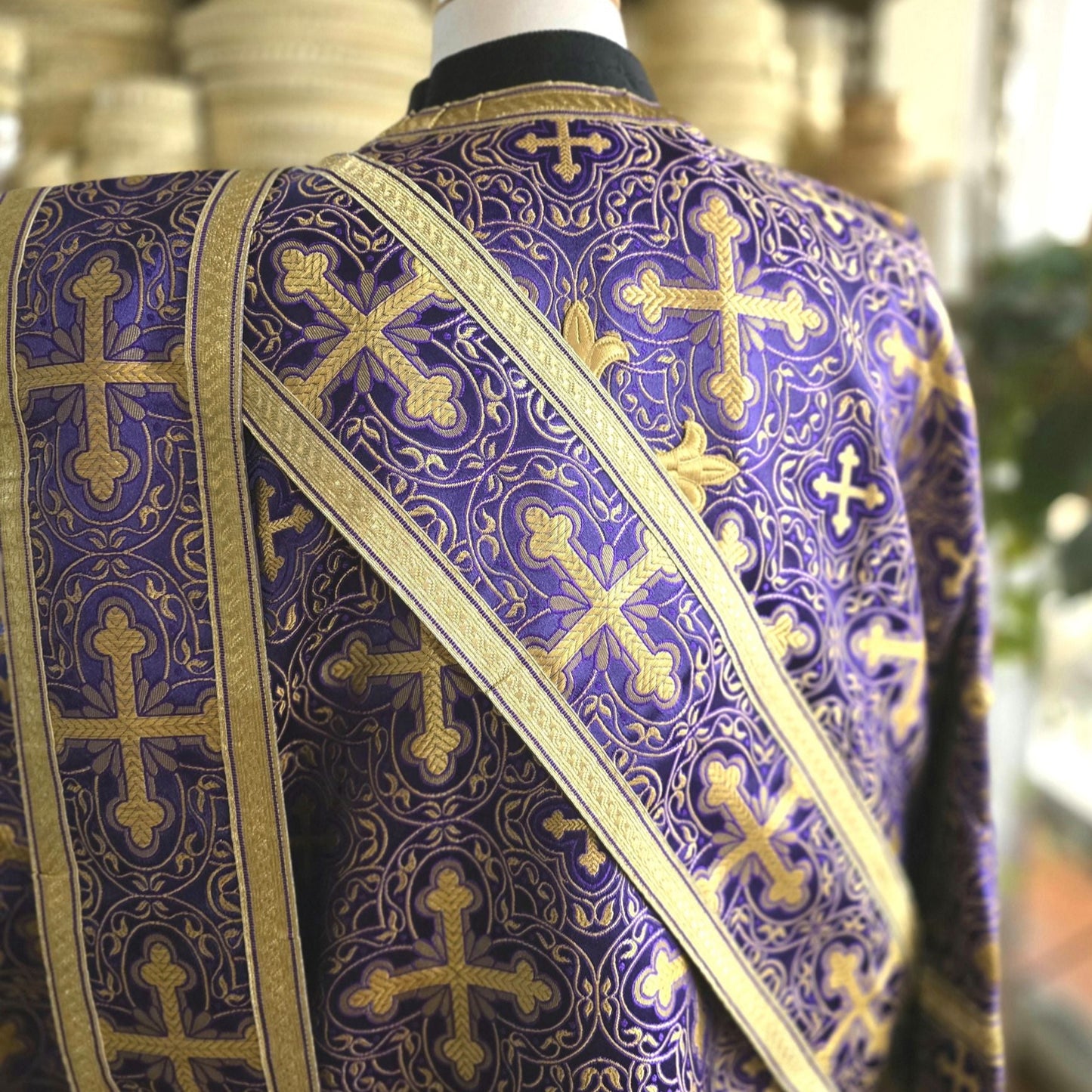 Purple liturgical vestment with gold embroidery on a mannequin