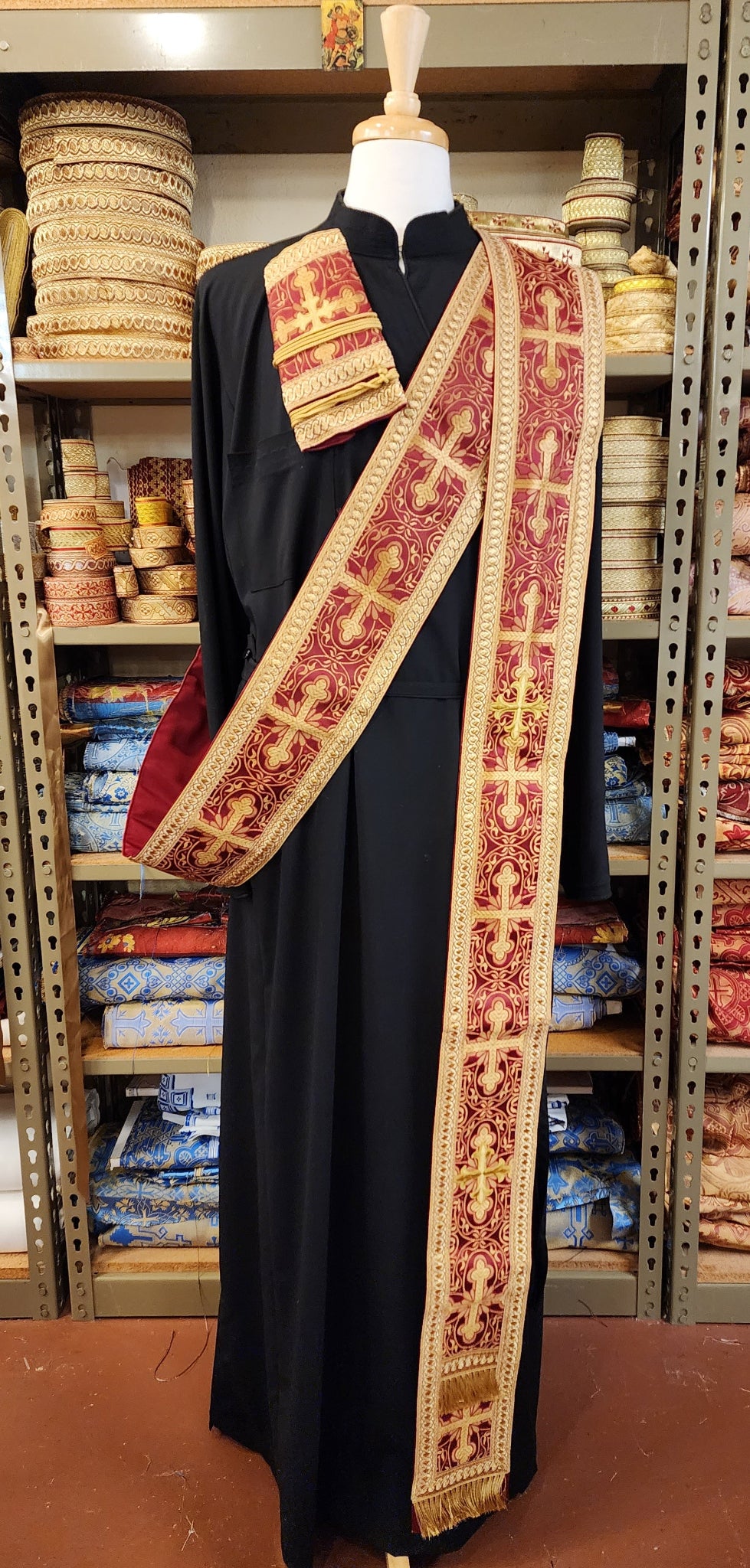 Greek Orthodox deacon orarion and cuff in burgundy brocade on tailors form with black cassock