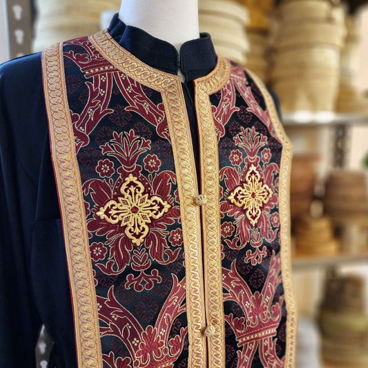 Decorative robe with intricate patterns on a mannequin against a blurred background